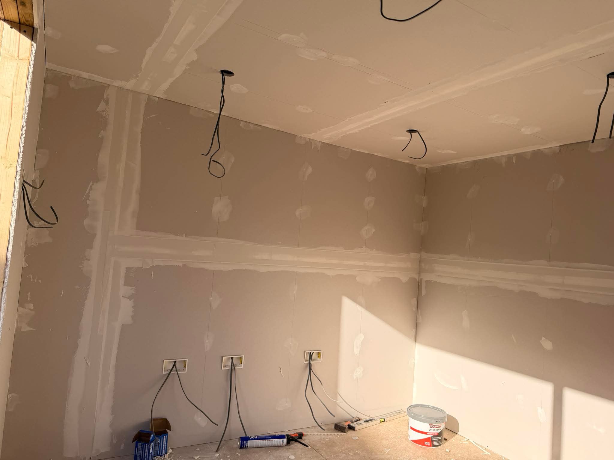 Garden studio interior — plastered walls and first-fix electrics